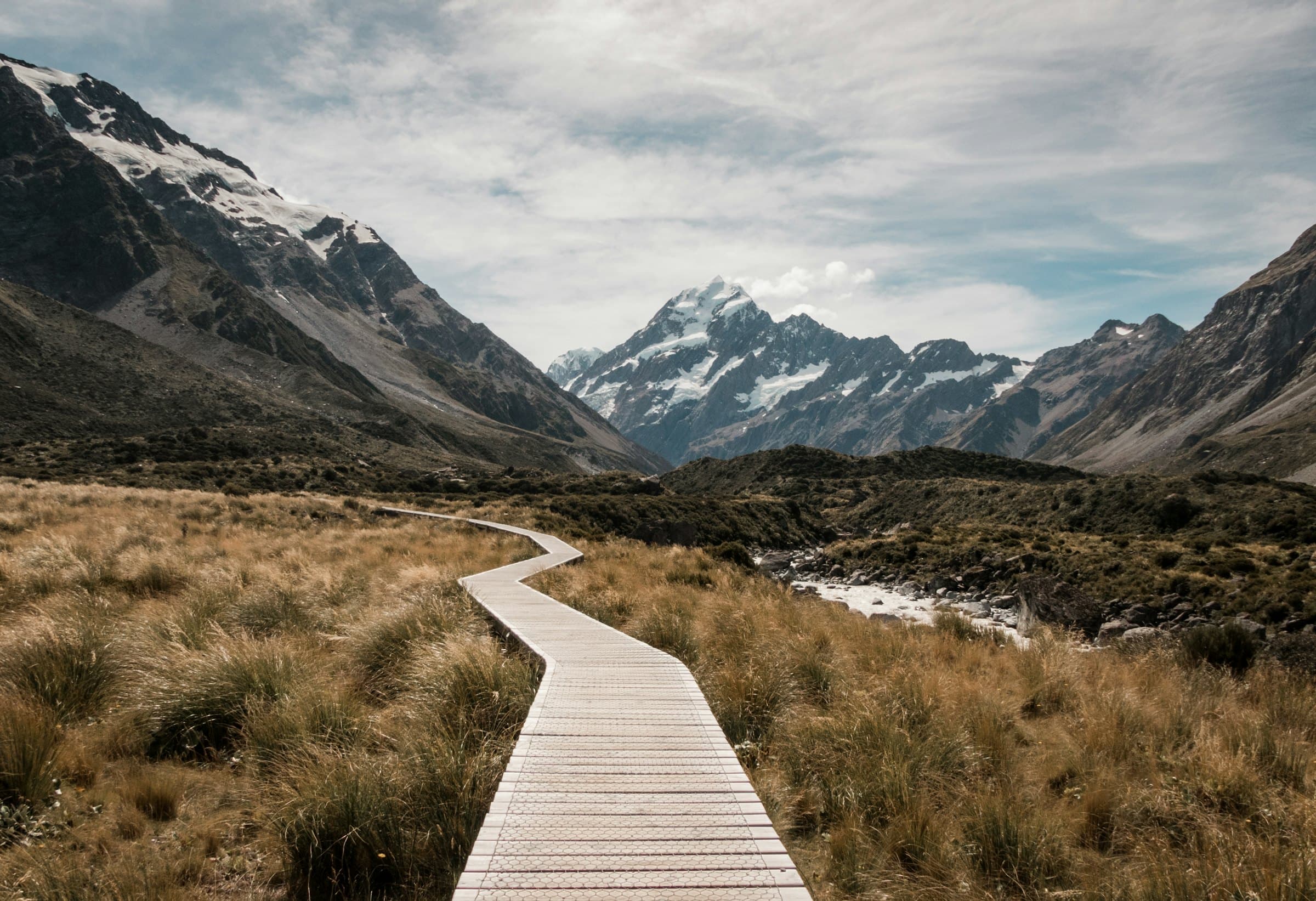 The Hooker Valley boardwalk winding through tussock towards Aoraki, Mount Cook.